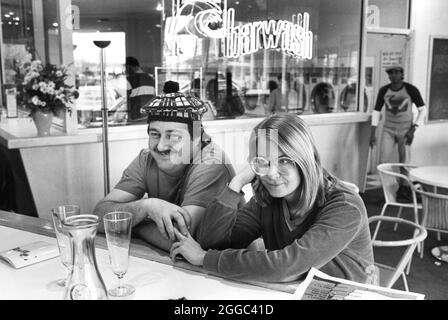 Austin Texas USA, ca. 1983: Ein Paar genießt alkoholische Getränke, während es darauf wartet, dass seine Wäsche im neuen Food Service Concept Barwash, einer Kombination aus Wäscherei und Bar, fertig ist. ©Bob Daemmrich Stockfoto