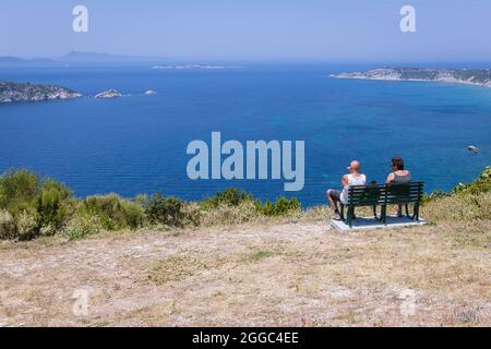 Bänke am Ionischen Meer Aussichtspunkt im Dorf Afionas auf der griechischen Insel Korfu, Blick auf die Inseln Gravia und Varkoules Stockfoto