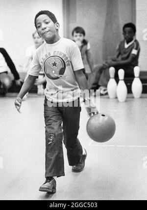 Austin Texas USA, 1984: Schwarzer Schüler der vierten Klasse Patrick Skeaton, der sein rechtes Bein aufgrund einer Spina bifida verlor, Bowls während des Sportunterrichts an der Wooten Elementary School, während er auf seiner neuen Beinprothese ging. ©Bob Daemmrich Stockfoto