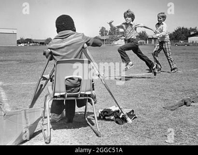 Austin Texas USA, 1984: Der schwarze Schüler Patrick Skeaton, der sein rechtes Bein aufgrund einer Spina bifida verlor, benutzt Holzkrücken, um an der Wooten Elementary School in Austin, Texas, zu kommen, während er in den regulären Unterricht integriert wird. Später wurde er mit einer Beinprothese ausgestattet. Teil einer erweiterten Fotofunktion. ©Bob Daemmrich Stockfoto