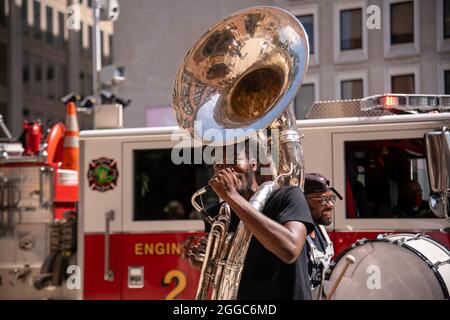 Washington, USA. August 2021. Musiker spielen, während Umweltaktivisten am 30. August 2021 durch Washington, DC, marschieren, um in den Büros von Lobbying-Firmen gegen ihre Arbeit im Namen der fossilen Energiewirtschaft zu protestieren. Der Protest war zum 16. Jahrestag des Hurrikans Katrina geplant. (Foto: Matthew Rodier/Sipa USA) Quelle: SIPA USA/Alamy Live News Stockfoto