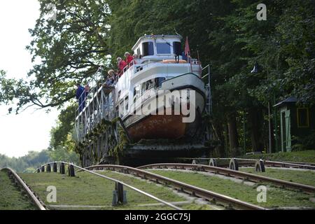 DRULITY, POLEN - 15. Sep 2015: Ein Passagierboot überquert schräges Flugzeug im Elblag Kanal, Drulity Stockfoto