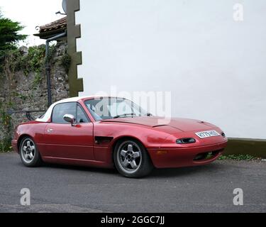 August 2021 - Älter modifizierter und abgesenkter Mazda MX5 Sportwagen auf der Straße in Cheddar Somerset, Großbritannien geparkt. Stockfoto