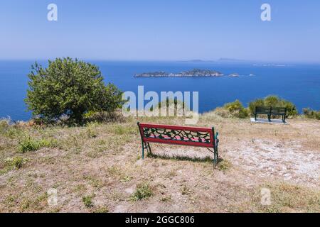 Bänke am Ionischen Meer Aussichtspunkt im Dorf Afionas auf der griechischen Insel Korfu, Blick auf die Inseln Gravia und Varkoules Stockfoto