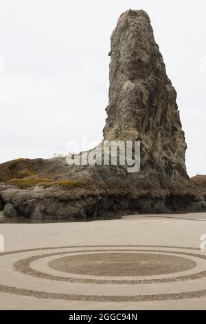 Konzentrische Kreise eines Sandlabyrinths neben einem Meeresstapel in Bandon, Oregon, USA. Stockfoto