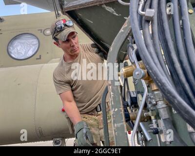 Die 82nd Airborne Division ist ein Fallschirmjäger, der der 82nd Combat Aviation Brigade zugewiesen wurde, und bereitet einen CH-47 Chinook vor, der auf eine C-17 Globemaster III der US-Luftwaffe am Hamid Karzai International Airport in Kabul, Afghanistan, im August 28 geladen werden soll. Der Chinook. Ist eines der Ausrüstungsgegenstände, die nach dem Ende der Militärmission in Afghanistan in die USA zurückkehren Stockfoto