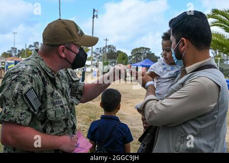 MARINESTÜTZPUNKT ROTA, Spanien (Aug 29, 2021) EIN Seemann aus der nach vorne entsendeten Abteilung des Regionalen Wartungszentrums (FDRMC) Rota interagiert mit einem Kind, das aus Afghanistan in einer provisorischen Unterkunft in der Naval Station (NAVSTA) Rota evakuiert wurde, 29. August 2021. NAVSTA Rota unterstützt derzeit die Mission des Außenministeriums, um die sichere Ausreise und Umsiedlung von US-Bürgern, Empfängern von Sondervisa für Immigration und gefährdeten Bevölkerungsgruppen aus Afghanistan zu erleichtern. (USA Navy Foto von Yeoman 3rd Class Sarah Weaver) Stockfoto