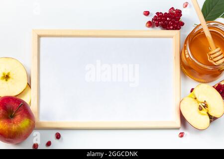 Happy Rosh Hashanah. Rahmen für Glückwunschtext. Äpfel, Granatäpfel und Honig auf weißem Hintergrund. Traditionelles Judentum Stockfoto