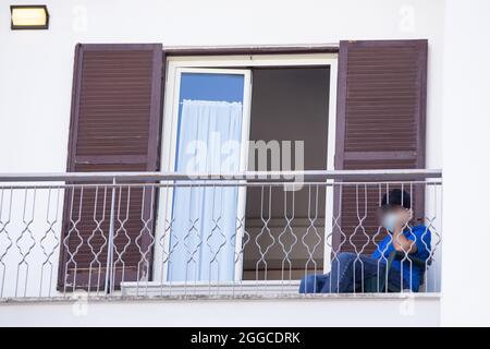 Rom, Italien. August 2021. Afghanischer Flüchtling auf einem Balkon des Hostels Villa Monte Mario in Rom. Nicola Zingaretti, Präsident der Region Latium, besuchte das Hostel Villa Monte Mario im römischen Stadtteil Balduina, das 52 Flüchtlinge beherbergt, die in den letzten Tagen aus Afghanistan angereist sind und sich der Anti-Covid-19-Impfung unterziehen werden. (Foto von Matteo Nardone/Pacific Press) Quelle: Pacific Press Media Production Corp./Alamy Live News Stockfoto