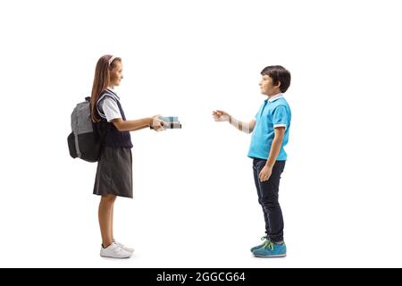 Schulmädchen, die einem kleinen Jungen Bücher auf weißem Hintergrund gibt Stockfoto