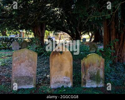 Alte abgenutzte Grabsteine auf einem englischen Kirchenfriedhof. Stockfoto