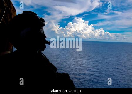SÜDCHINESISCHES MEER (AUG. 27, 2021) Naval Aircrewmen (Helicopter) 2nd Class Nicolas Lopez aus Artesia, Kalifornien, hält während der Flugoperationen in einem MH-60S Seahwak Hubschrauber Ausschau, der den „Blackjacks“ des Helicopter Sea Combat Squadron (HSC) 21 an Bord des Independence-Variant Littoral Combat Ship USS Tulsa (LCS 16), 27. August 2021 zugewiesen wurde. Tulsa, Teil von Destroyer Squadron Seven, ist im Einsatzgebiet der 7. US-Flotte im Rotationseinsatz, um die Interoperabilität mit Partnern zu verbessern und als einsatzbereite Kraft zur Unterstützung einer freien und offenen Region im Indo-Pazifik-Raum zu fungieren. (USA Navy ph Stockfoto