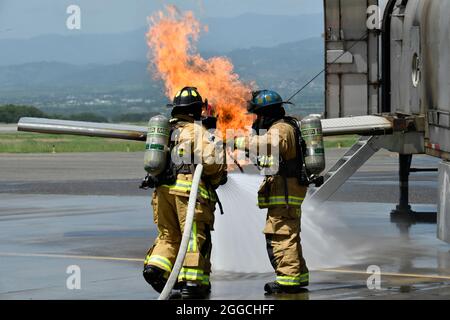 Feuerwehrleute der US-Luftwaffe mit dem 612. Luftwaffenstützpunkt führen während der Übung CENTAM SMOKE auf dem Soto Cano Air Base, Honduras, August 25, Live-Feuerübungen mit honduranischen, costaricanischen und guatemaltekischen Kollegen durch. Während der Übung arbeiteten fünf costaricanische, fünf guatemaltekische und 15 honduranische Feuerwehrleute Seite an Seite mit den Kollegen der US-Luftwaffe, um Sicherheitspraktiken, Techniken zur strukturellen und Hubschrauberbrandunterdrückung, Fahrzeugexposition und Flugzeugkenntnisse zu schärfen. (USA Armeefoto von Martin Chahin) Stockfoto