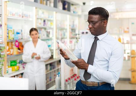 Mann hält Flasche mit Haarpflegeprodukt Stockfoto