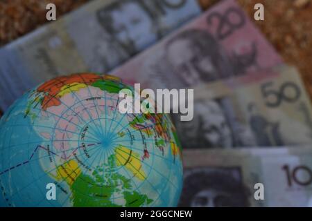 Erdglobenkarte der Arktis, die in der Natur auf einer Gruppe von Banknoten sitzt. Stockfoto