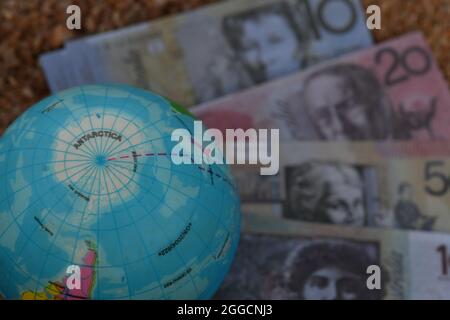 Erdglobenkarte der Antarktis, die in der Natur auf einer Gruppe von Banknoten sitzt. Stockfoto