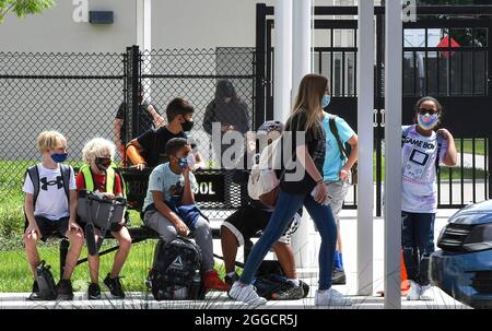 Orlando, Usa. August 2021. Schüler mit Gesichtsmasken warten darauf, von ihren Eltern an der Pershing School in Orlando abgeholt zu werden. Gesichtsmasken sind für alle Schüler von Orange County bis zum 30. Oktober 2021 erforderlich, nachdem ein Richter in Florida das Verbot von Schulgesichtsmasken durch Gouverneur Ron DeSantis verwarf. Kredit: SOPA Images Limited/Alamy Live Nachrichten Stockfoto