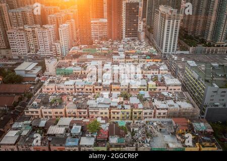 Erstaunlich bunte chaotische Dachterrasse auf dichten alten Wohnhaus in Kowloon, Hong Kong, Abend. Stockfoto