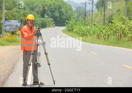 Vermessungsingenieur Arbeiter, die Messung mit Theodolit auf Straßenarbeiten.Survey Ingenieur auf der Baustelle. Stockfoto