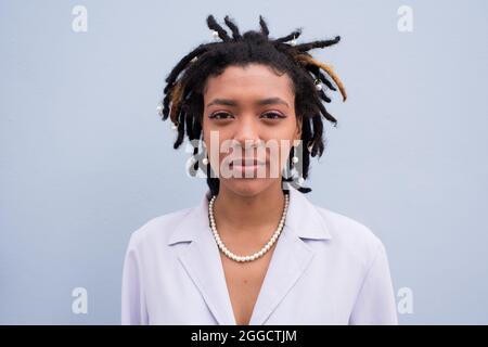 Junge Frau schoss aus der Nähe vor pastellblauem Hintergrund Stockfoto