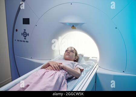 Wenig Patient in Kliniken, die sich einer mrt-Untersuchung unterziehen, während sie in ein CT-Gerät wechseln Stockfoto