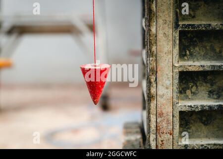 Pendel mit Pflaume zum Auffinden einer vertikalen Linie Stockfoto