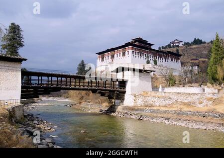 Rinpung Dzong (Buddhistisches befestigtes Kloster) und die Freischwinger-Brücke Nemi Zam über den Pa Chhu (Fluss), Paro, Bhutan - am späten Nachmittag, 2017. Februar Stockfoto