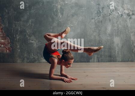 Junge Mädchen professionelle Turnerin Frau tanzen rhythmische Gymnastik im Studio. Stockfoto