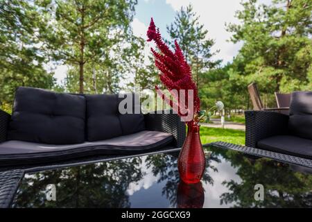 Sitzecke, Sofa, Couchtisch, rote Vase mit einer Blume. Hochwertige Fotos Stockfoto