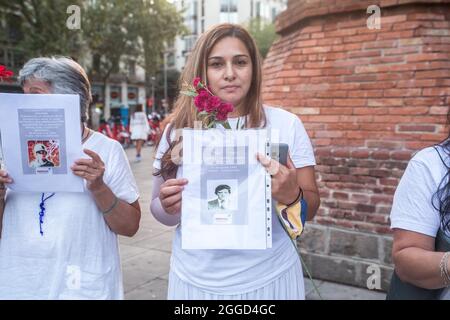 Barcelona, Katalonien, Spanien. August 2021. Die Demonstranten sind mit Fotos von Opfern der kolumbianischen Armee zu sehen.rund 200 Menschen haben vor dem Arc de Triomf in Barcelona gegen die 6402 außergerichtlichen Tötungen demonstriert, die die Armee im Zusammenhang mit dem bewaffneten Konflikt in Kolumbien verübt hat, ein Phänomen, das als "falsche positive" bekannt ist. Die Demonstration fand anlässlich des Internationalen Tages der Opfer des gewaltsamen Verschwindens statt, der jeden 30. August begangen wird und an dem Ricardo ''Profe'', einer der als erste Verteidigungslinie bekannten, in der Anti-Regierung teilnahm Stockfoto