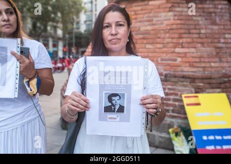 Barcelona, Spanien. August 2021. Der Protestierende ist mit einem Foto von Opfern der kolumbianischen Armee zu sehen. Rund 200 Menschen haben vor dem Arc de Triomf in Barcelona gegen die 6402 außergerichtlichen Tötungen demonstriert, die von der Armee im Zusammenhang mit dem bewaffneten Konflikt in Kolumbien begangen wurden, ein Phänomen, das als „falsche positive“ bekannt ist. Die Demonstration fand anlässlich des Internationalen Tages der Opfer des gewaltsamen Verschwindens statt, der jeden 30. August begangen wird und an dem Ricardo 'Profe', einer der als erste Verteidigungslinie bekannten, an den regierungsfeindlichen Protesten teilnahm. Kredit: D Stockfoto