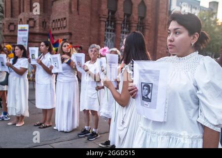 Barcelona, Spanien. August 2021. Demonstranten werden mit Fotos von Opfern der kolumbianischen Armee gesehen. Rund 200 Menschen haben vor dem Arc de Triomf in Barcelona gegen die 6402 außergerichtlichen Tötungen demonstriert, die von der Armee im Zusammenhang mit dem bewaffneten Konflikt in Kolumbien begangen wurden, ein Phänomen, das als „falsche positive“ bekannt ist. Die Demonstration fand anlässlich des Internationalen Tages der Opfer des gewaltsamen Verschwindens statt, der jeden 30. August begangen wird und an dem Ricardo 'Profe', einer der als erste Verteidigungslinie bekannten, an den regierungsfeindlichen Protesten teilnahm. Kredit Stockfoto