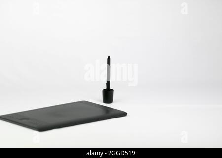 Digitales schwarzes Zeichentablett auf weißem Hintergrund mit Zeichenstift-Eingabestift Stockfoto