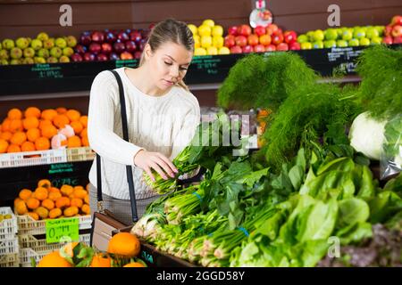 Mädchen, die Gemüse im Supermarkt auswählen Stockfoto