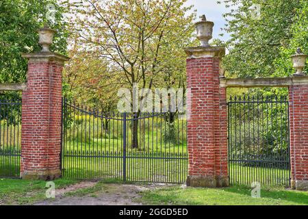 Schmiedeeisernes Eingangstor zum Garten. Ziegelsäulen und Sandsteindekorationen. Schloss Westerwinkel, Nordrhein-Westfalen, Deutschland Stockfoto