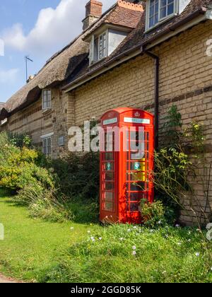 Ein alter roter Telefonkioské im Dorf Upper Stowe Northamptonshire, der jetzt als Defibrillator-Einheit genutzt wird, gehört zum BT und verabschiedet EIN Kiosk-System. Stockfoto