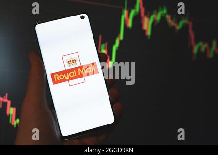 Royal Mail-Logo auf dem Smartphone in der Hand mit dunklen Aktienkurskurs-Hintergrund. Royal Mail Plc Postal Service Unternehmen Lagerkonzept. Swansea, Großbritannien - 26. August 2021. Stockfoto