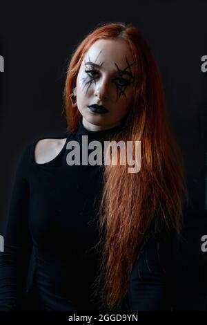 Halloween Hexe Frau mit langen Haaren und schönen Make-up auf schwarzem Hintergrund. Stockfoto