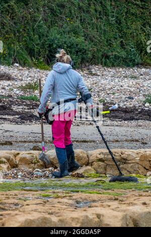 Metalldetektor, Schatzsuche, Dame-Metall-Detektion, Frau-Metall-Detektion am Strand, Frau mit einem modernen Metalldetektor am Strand. Suchen Stockfoto