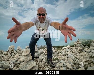 Fröhlicher Wanderer auf dem Gipfel des Berges Stockfoto