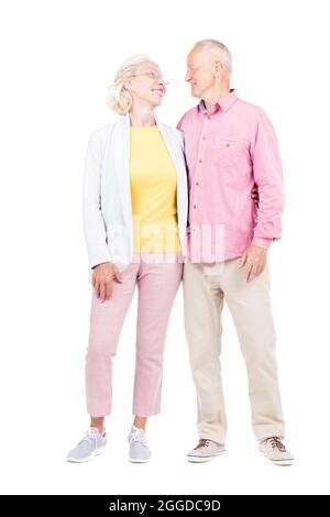 Vertikale Ganzkörperaufnahme eines modernen älteren kaukasischen Mannes und einer verliebten Frau, die zusammen stehen, weißer Hintergrund Stockfoto