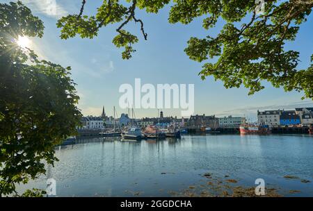 Der Hafen von Stornoway wird am sonnigen Sommertag vom Gelände des Lews Castle aus gesehen. Stockfoto