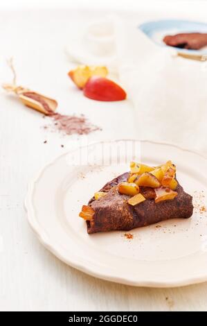 Dunkle Schokolade Crepes garished mit Rührbraten Apfel Stockfoto