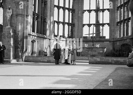 Ein Blick auf Ihre Majestät, die Königin und den Herzog von Edinburgh, die in den Ruinen der alten Kathedrale mit Provost Howard am Tag der Grundsteinlegung für die neue Coventry Cathedral stehen. Dieses Bild wurde als Teil des Breaking New Ground Project in Zusammenarbeit mit dem John Laing Charitable Trust in den Jahren 2019-20 katalogisiert. Stockfoto