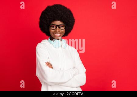 Foto von schönen Brünette Haare junge Dame gekreuzte Arme tragen Brillen weißen Hoodie auf rotem Hintergrund isoliert Stockfoto