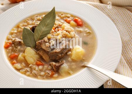 Schüssel mit schmackhafter Rindergerstensuppe, Nahaufnahme Stockfoto