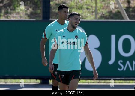 Oeiras, Portugal. August 2021. Die Portugiesen Ruben Dias (R) und Cristiano Ronaldo nehmen am 31. August 2021 an einer Trainingseinheit im Trainingslager Cidade do Futebol in Oeiras, Portugal, Teil, um sich auf das bevorstehende Qualifikationsspiel der FIFA Fußball-Weltmeisterschaft Katar 2022 gegen Irland vorzubereiten. (Bild: © Pedro Fiuza/ZUMA Press Wire) Stockfoto