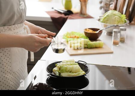 Frau bereitet gefüllte Kohlrollen in der Küche zu, Nahaufnahme Stockfoto