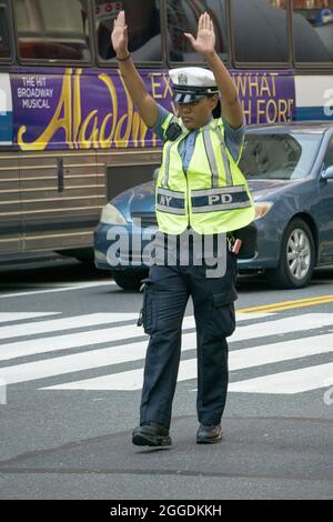 Eine attraktive New Yorker Polizistin leitet den Verkehr auf der 34th Street und der Park Avenue in Manhattan, New York City Stockfoto