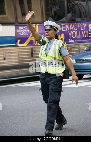Eine attraktive New Yorker Polizistin leitet den Verkehr auf der 34th Street und der Park Avenue in Manhattan, New York City Stockfoto